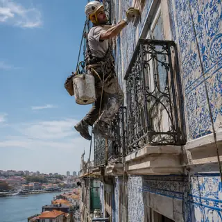 Técnico em acesso por cordas a recuperar fachada de azulejos